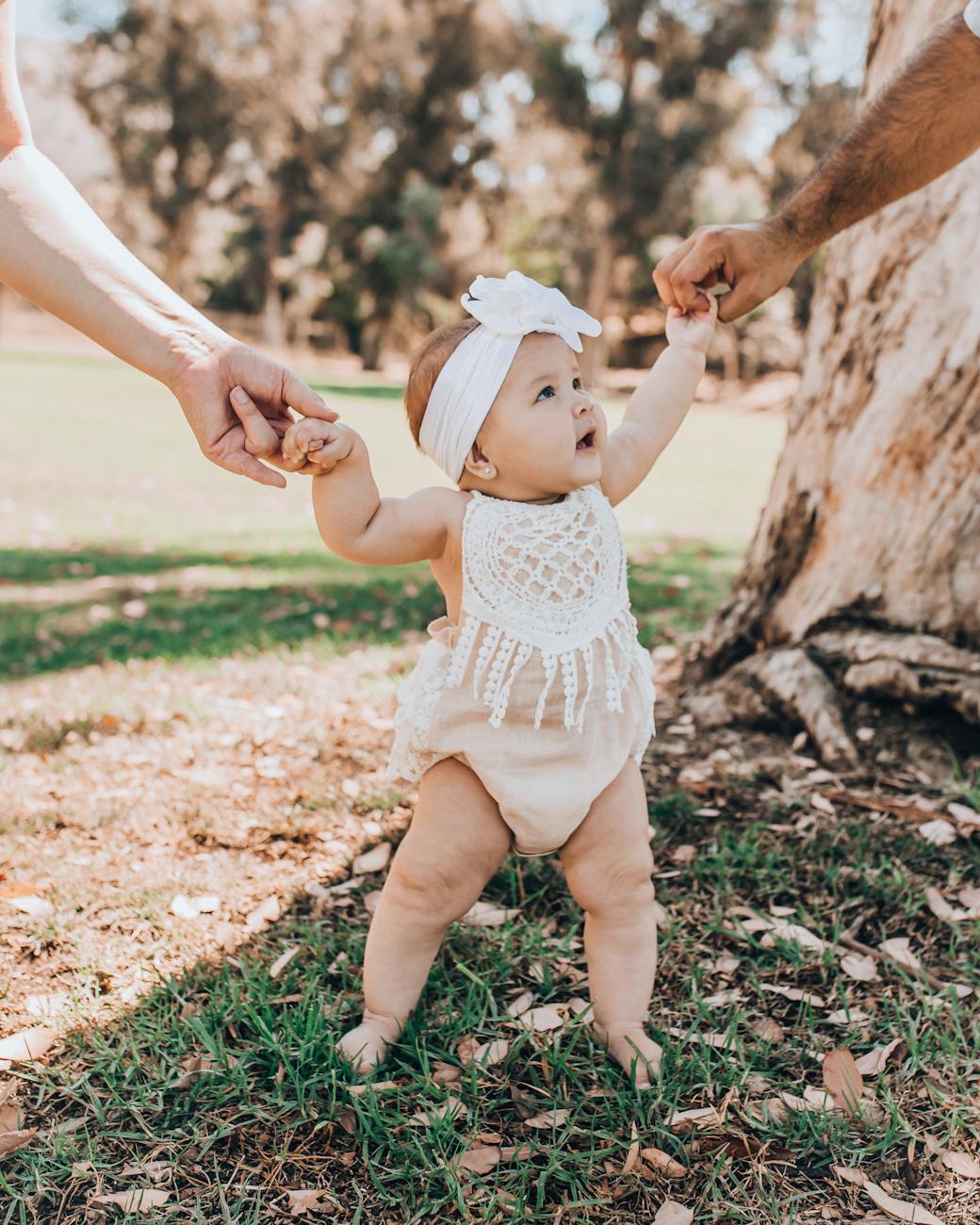 a baby girl standing on the grass